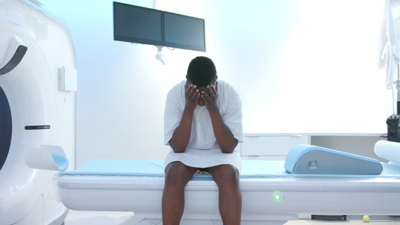 Dopo una pausa, il paziente alza la testa e apre gli occhi sul tavolo di scansione vicino al gantry, diventando vigile.