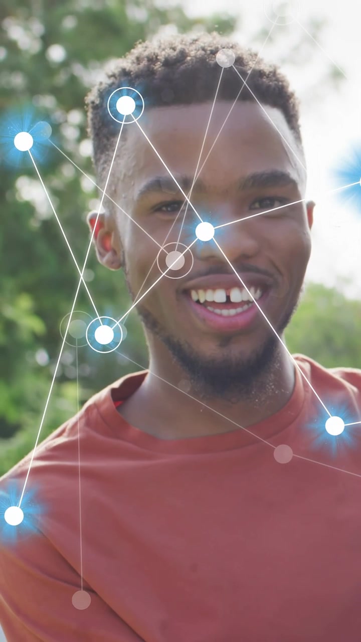 Vertical video: Man leaning toward partner in park, reacting to joke as blue AR nodes tracking face