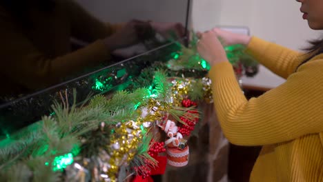 asian woman decorating fireplace on christmas day