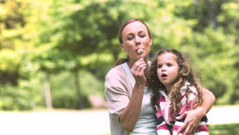 Smiling-daughter-in-slow-motion-blowing-a-dandelion