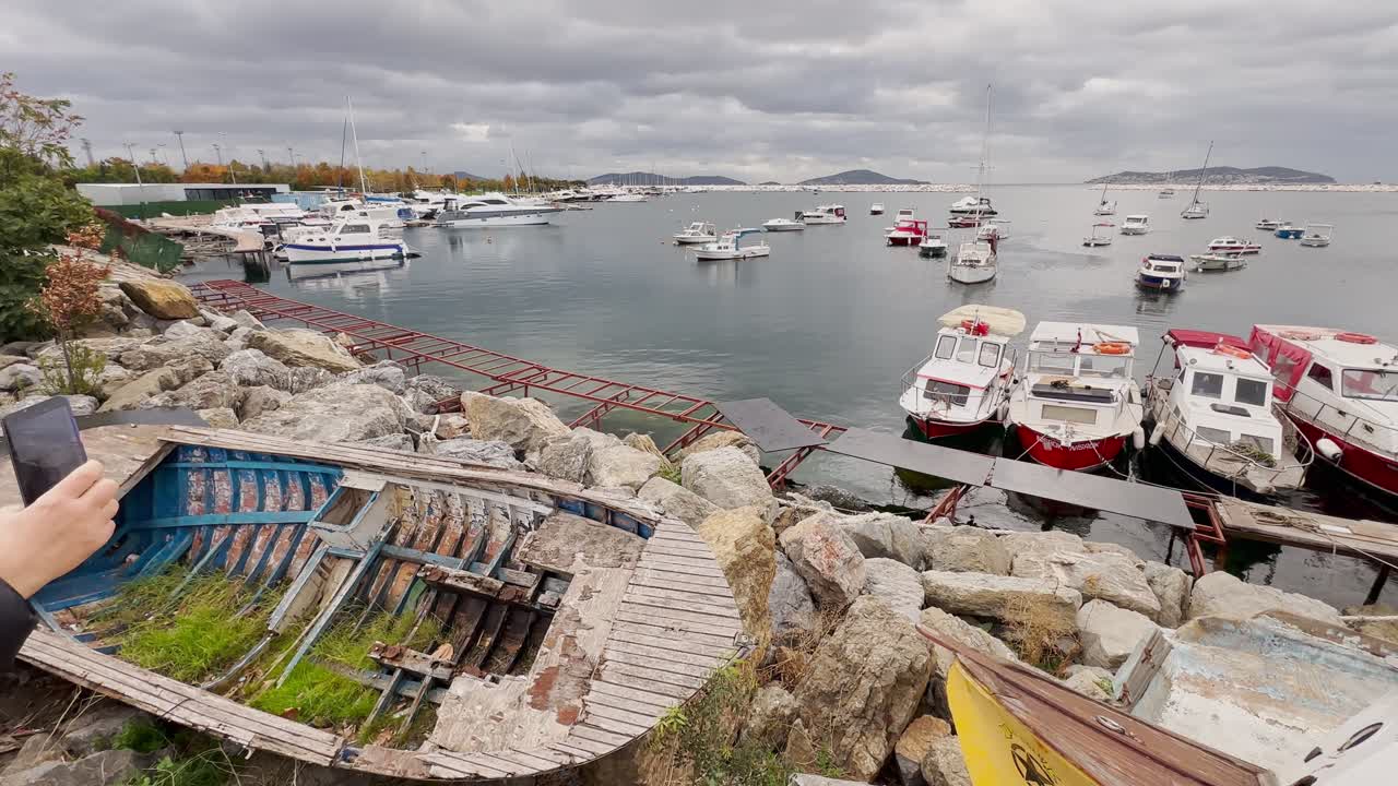 Old Damaged Boat at Harbor with Many Boats and Yachts