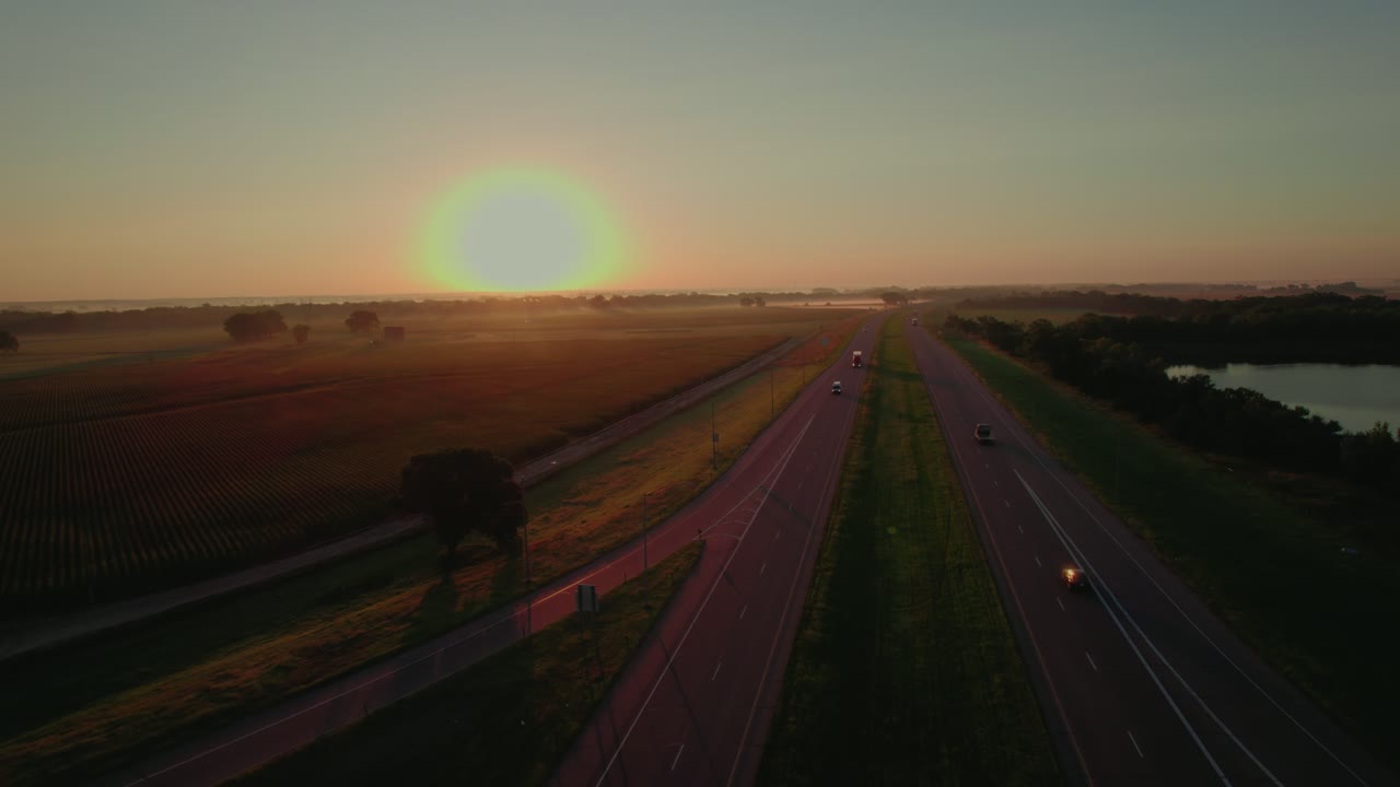 Semi trucks driving on the I-80 interstate highway in Nebraska during golden sunrise. Perfect for travel, infrastructure, and business concept videos