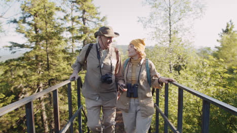 senior couple hiking on a mountain bridge