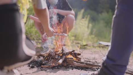 Children-on-a-summer-camp-hike-fry-sausages-on-a-campfire