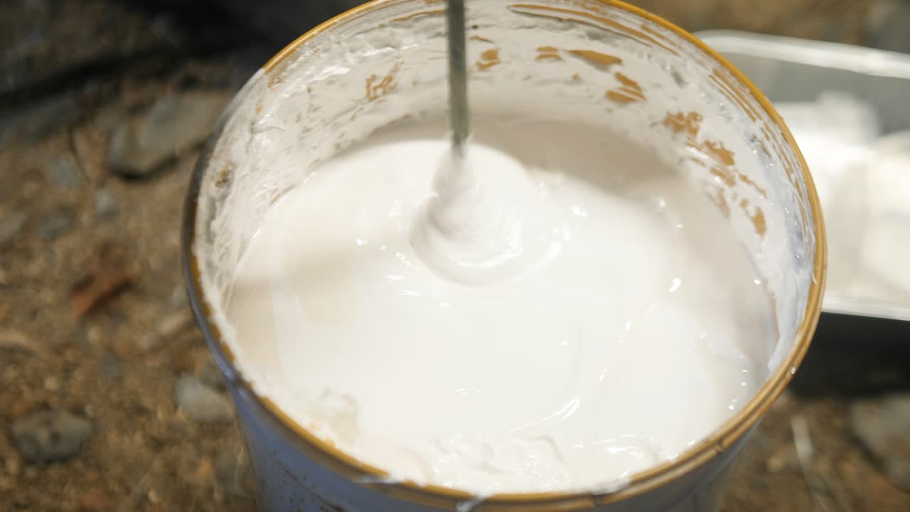 Verf mengen/roeren in een blik met behulp van een booropzetstuk.