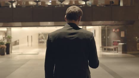 businessman walking in hotel lobby at night