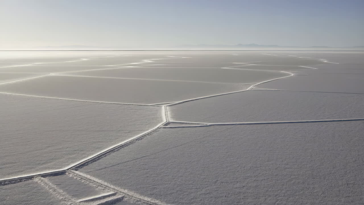 Expansive polygonal patterns on a salt flat under a bright sky