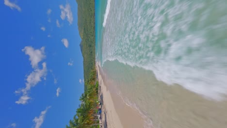 vuelo rápido y bajo sobre las aguas turquesas del caribe y las olas que chocan contra la playa