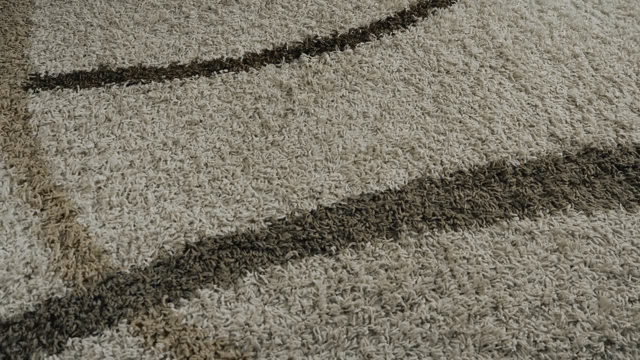 Diverse caucasian white hand holding a phone that is dialing and calling 911 emergency number falling on a carpet indoors. Smartphone screen is red person is injured, future crime scene or homicide