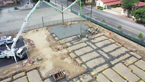antena notable sobre el sitio de construcción con grúa gigante y trabajadores que vierten cimientos de hormigón en ventura california 1