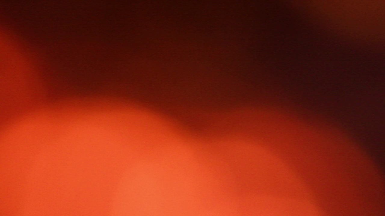 캠프 불의 불꽃은 초점 밖입니다. 오렌지 색조의 보케 배경.