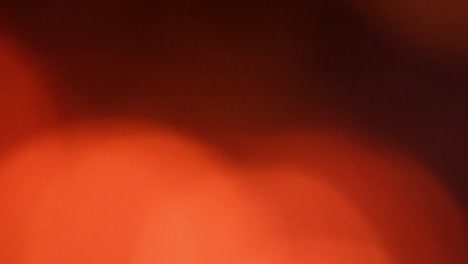 las brasas de una fogata están fuera de foco. fondo bokeh en tonos naranja.