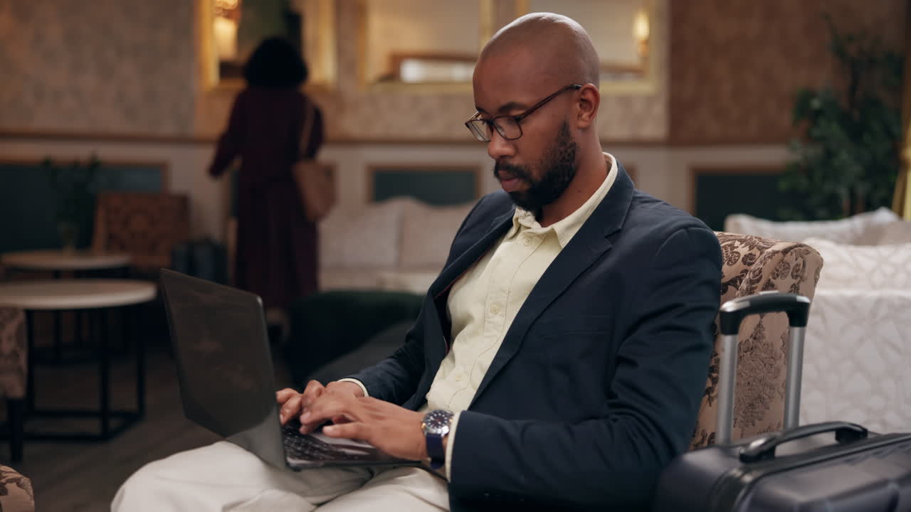 Man working on laptop in hotel lobby