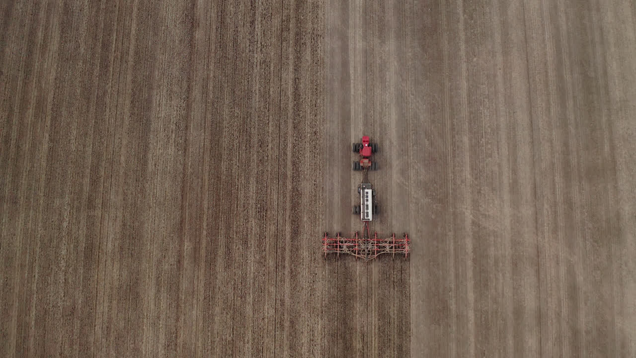 Veduta grandangolare a volo d'uccello di un agricoltore che semina un campo, Saskatchewan, Canada