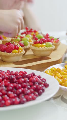preparing fruit tarts with berries