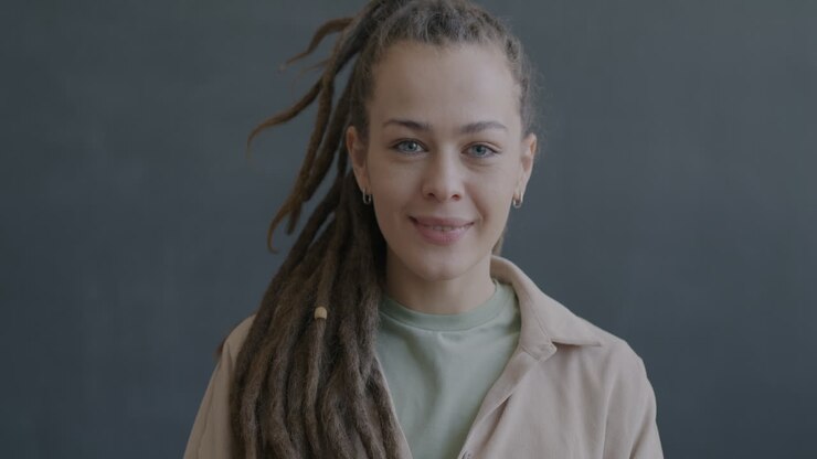 Donna con dreadlock che sorride e saluta