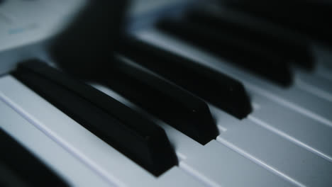 beautiful slow motion and super close-up shot of a musician cleaning his midi controller keyboard with a brush from an instrument cleaning kit in his home studio.