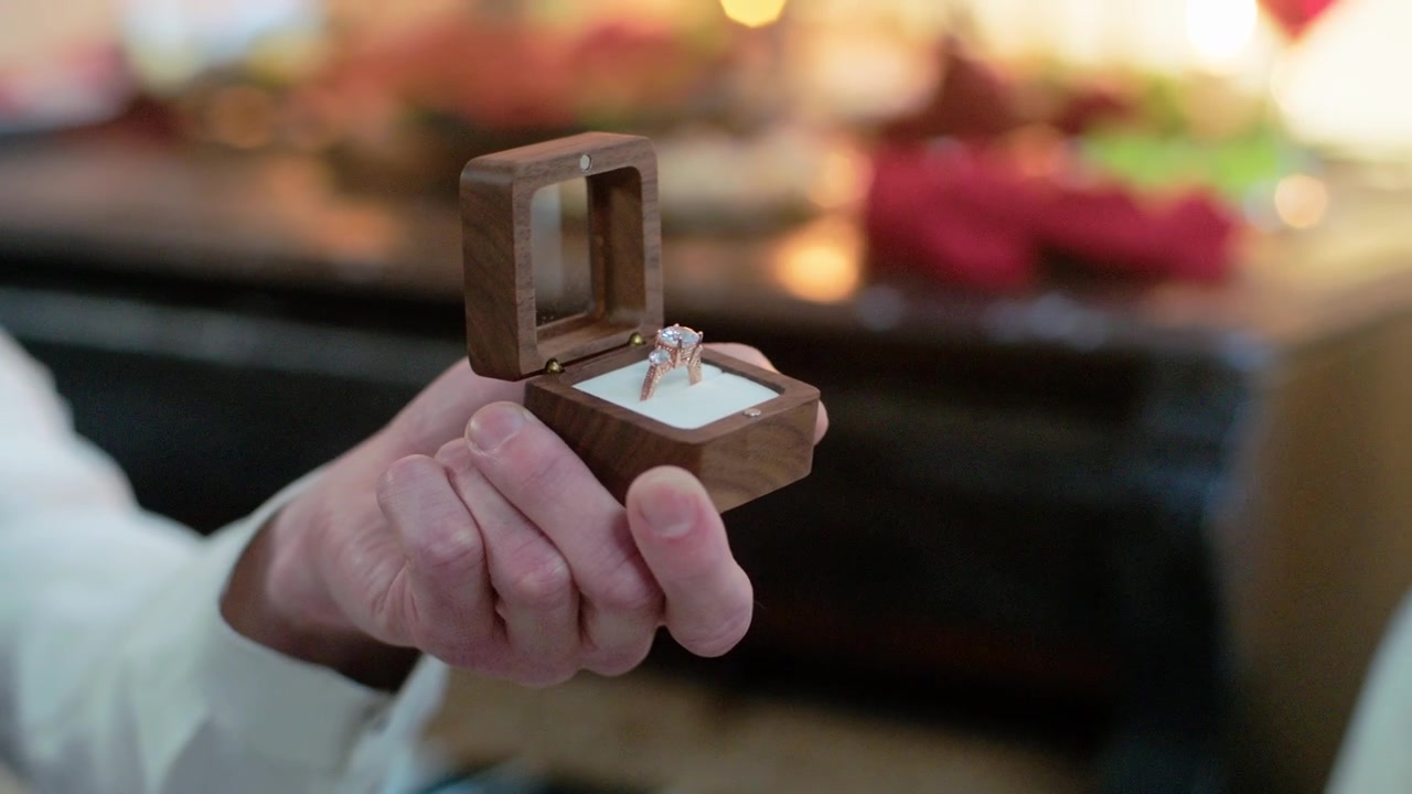 Hands Opening a Wooden Box to Reveal an Engagement Ring