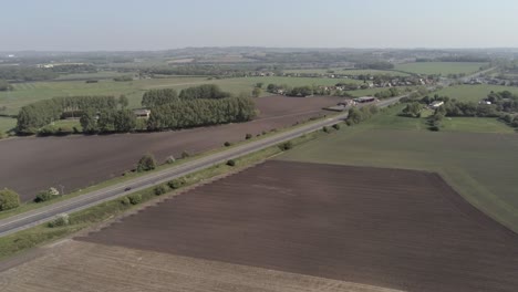 drone aerial view above british a580 east lancs highway in rural agricultural countryside slow pull back reveal