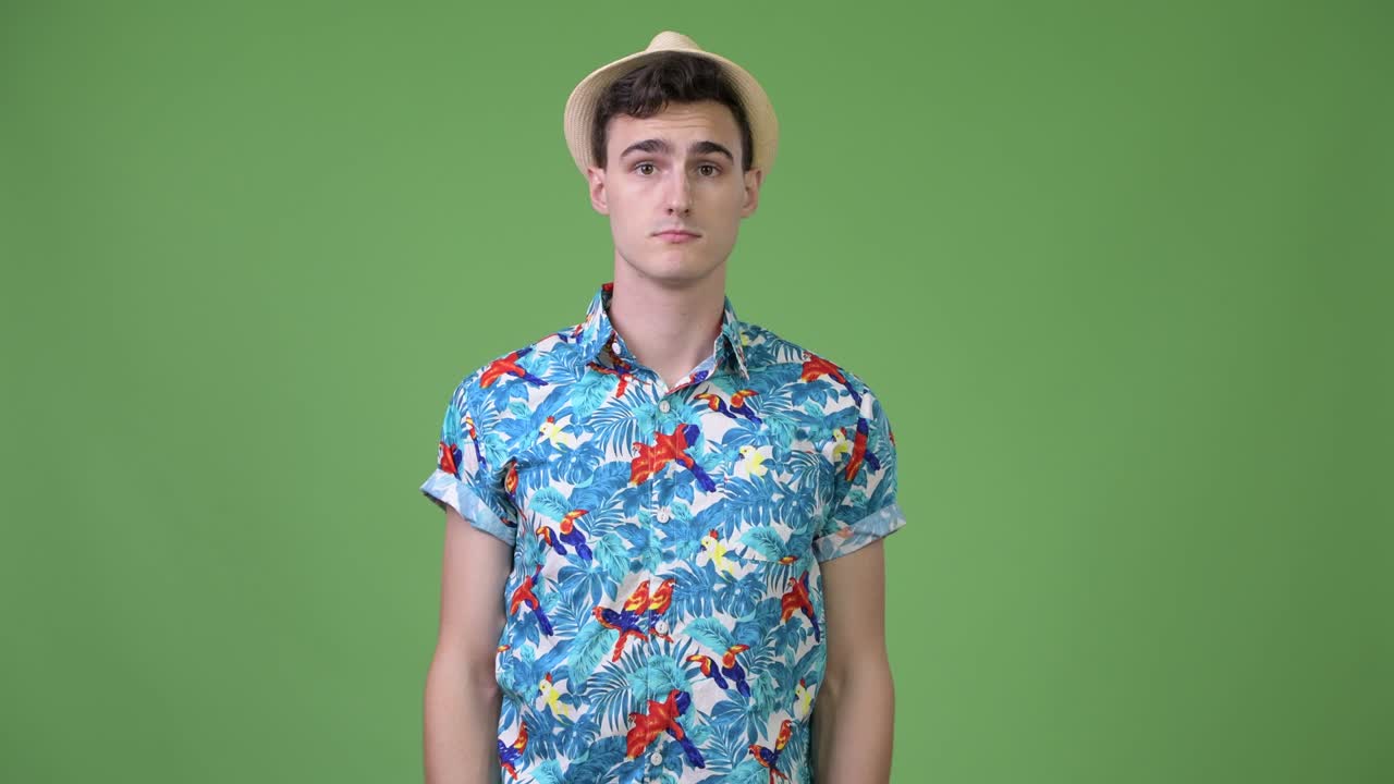 Young handsome tourist man shrugging shoulders