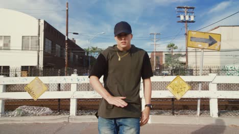 man hip hop dancing outside in street on sunny day