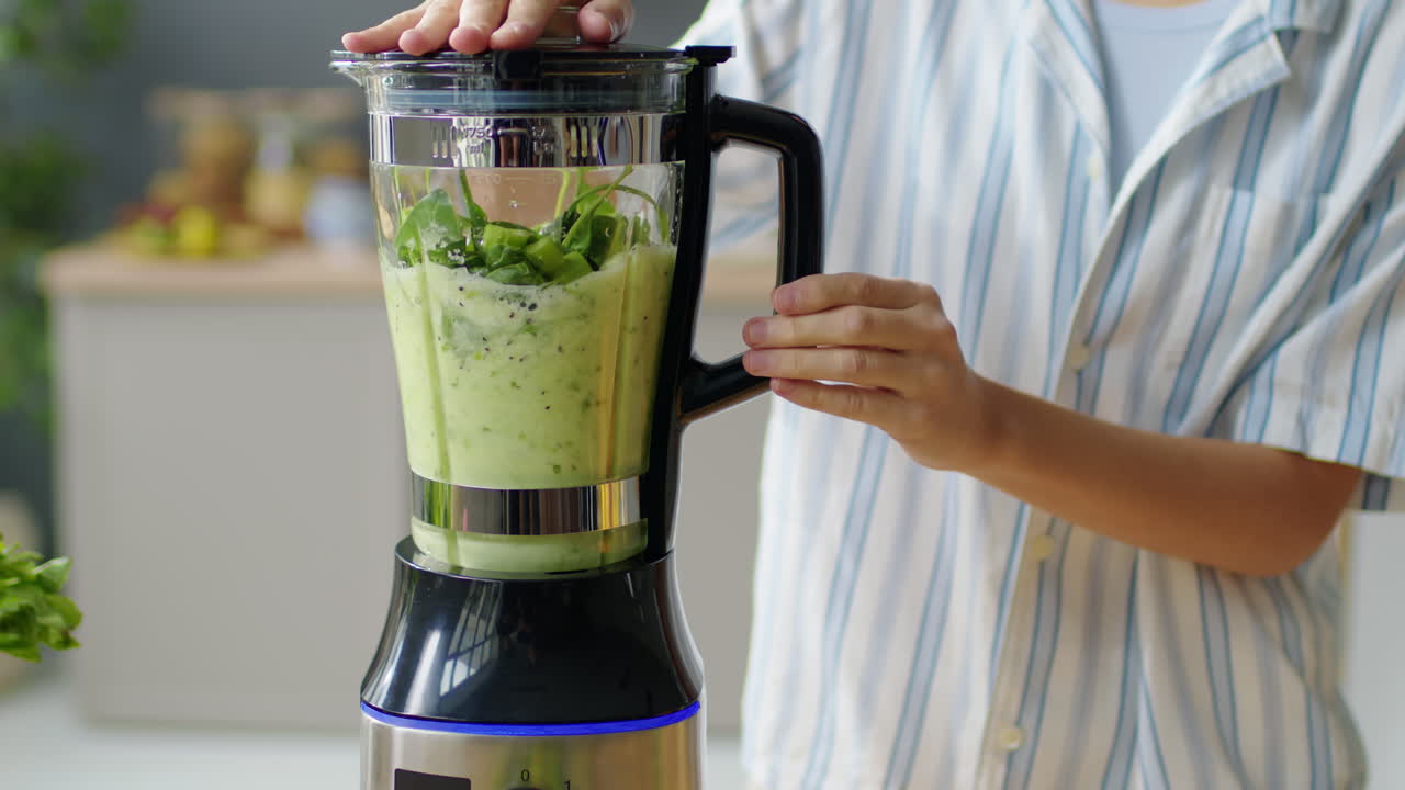 Woman Preparing Green Smoothie in Blender
