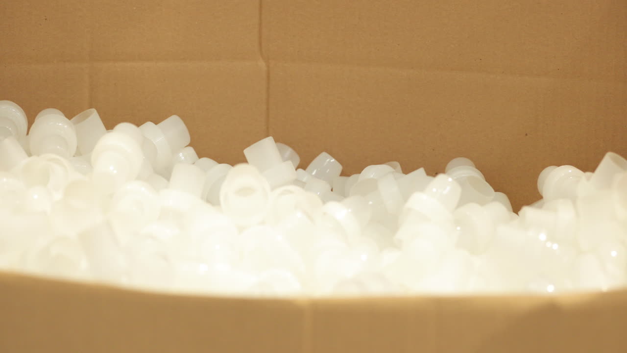 포장을 위해 판지 상자에 떨어지는 완성된 플라스틱 제품