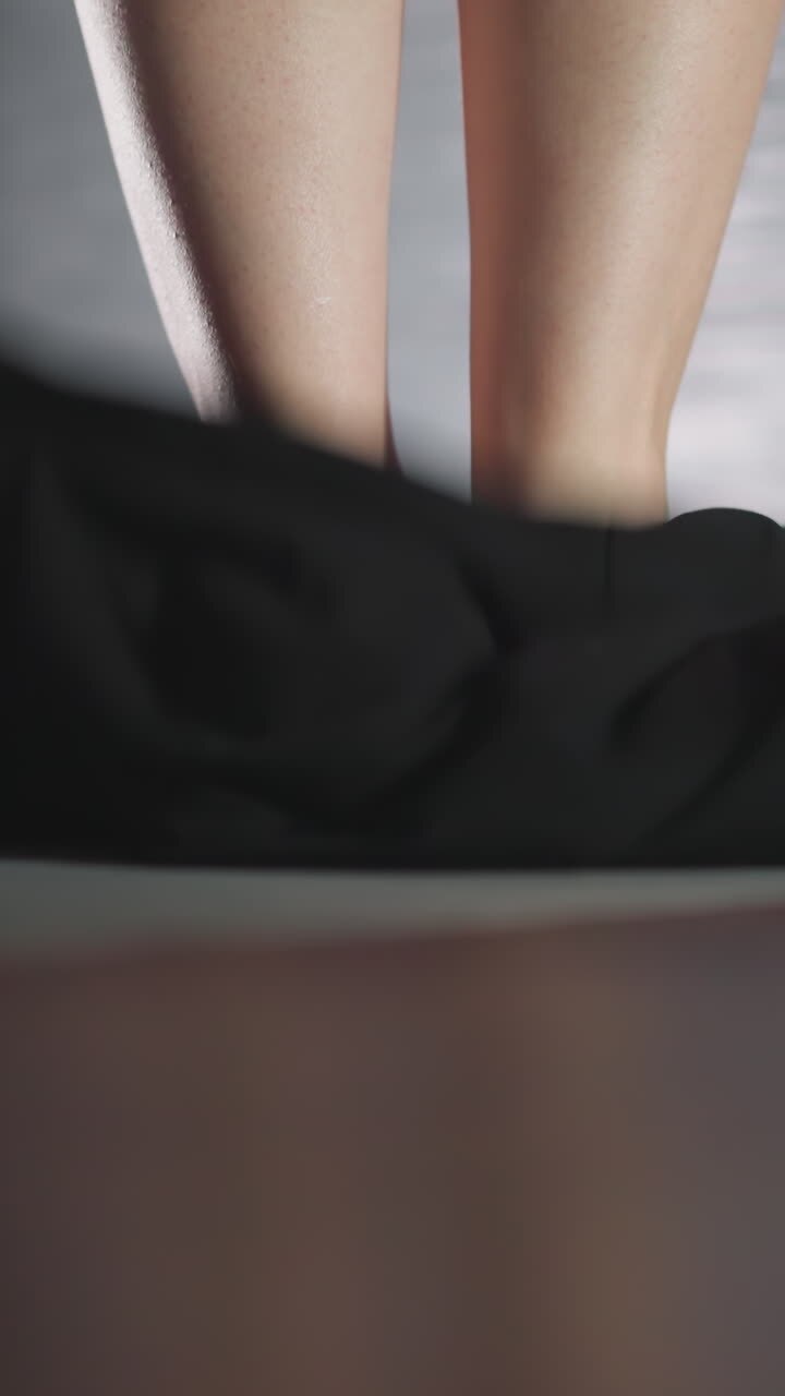 Barefoot woman and falling down gown in bathroom closeup. Graceful lady takes off silk robe and gets in bathtub at home. Woman prepares to wash body