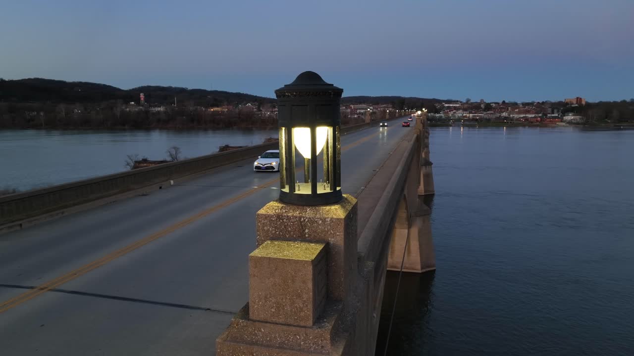 Aerial Orbit shot of light on top of Bridge with driving cars crossing Susquehanna River in Colombia Borough at night