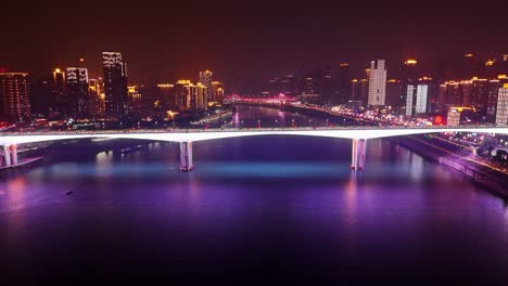aerial push in view of an illuminated bridge in chongqing, china. vibrant colors and modern architecture. bridge for cars and pedestrians