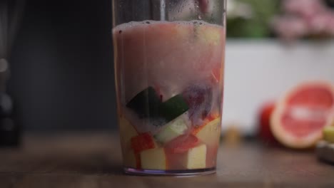 blending a fruit juice with a hand blender in slow motion