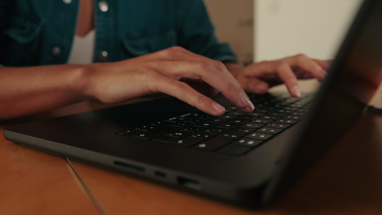 Nærbillede af persons hænder der taster på et bærbart tastatur