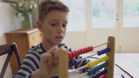 boy learning mathematics on abacus at table in a comfortable home 4k