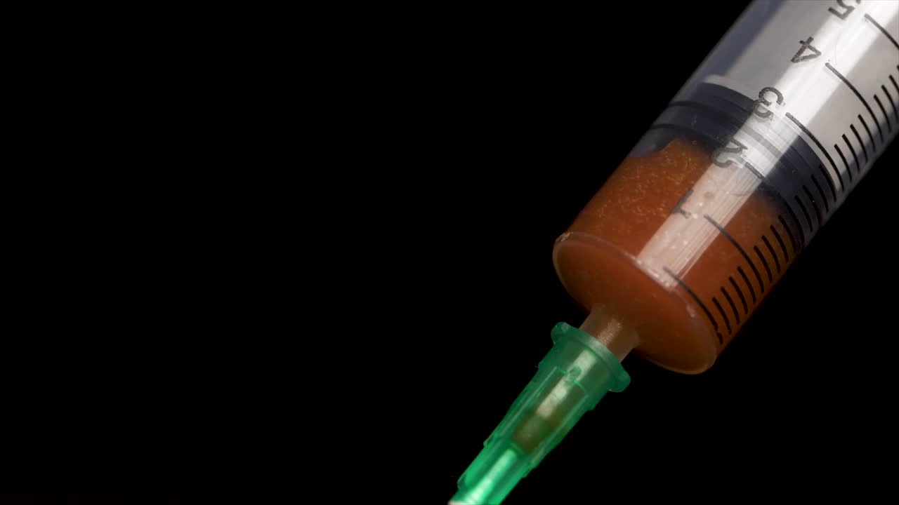Siringa usata con liquido marrone