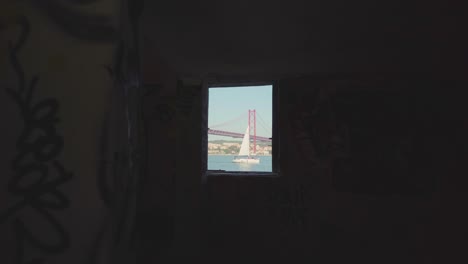 traveling reveal great river, sail boat and huge bridge through abandoned building window