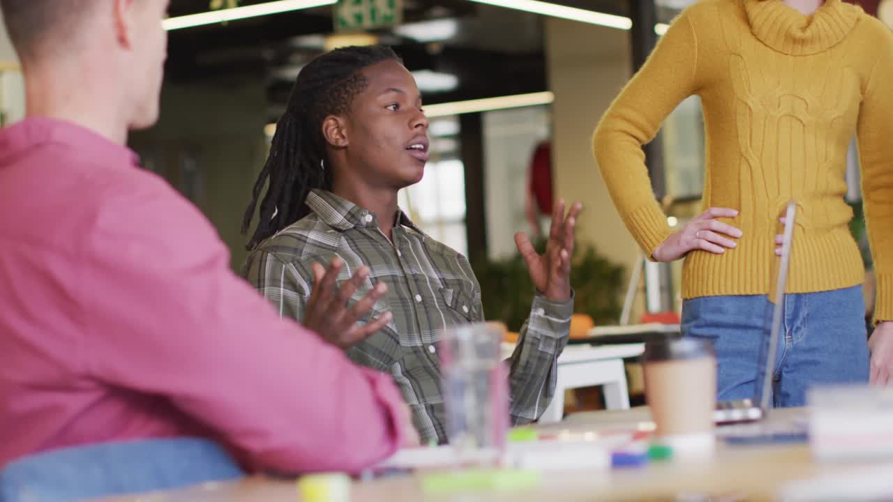 Happy diverse business people discussing work during meeting at office