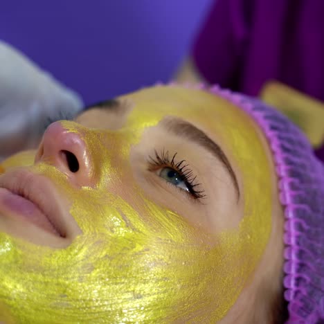 woman getting facial nourishing mask by beautician at spa salon. apply face mask, spa beauty treatment and skincare