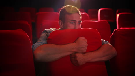 young man watching a scary film