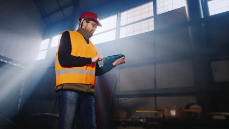 Engineer-works-in-a-warehouse-and-uses-a-tablet