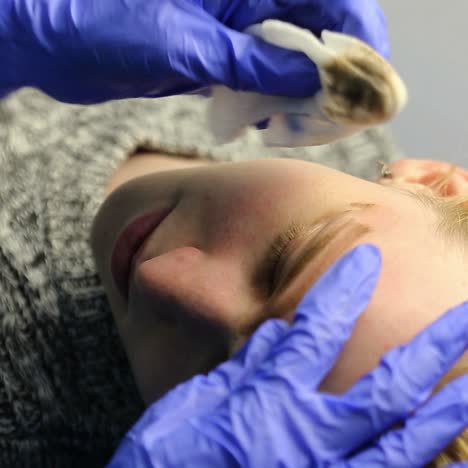mujer haciendo un tatuaje de cejas