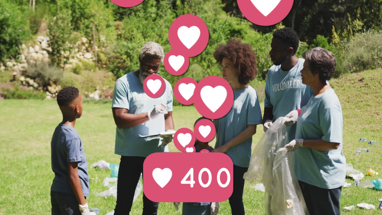 animación de los iconos del corazón de las redes sociales sobre felices voluntarios afroamericanos que limpian el campo