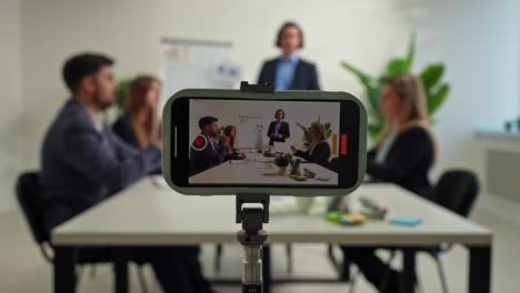 business meeting in progress being recorded on a smartphone