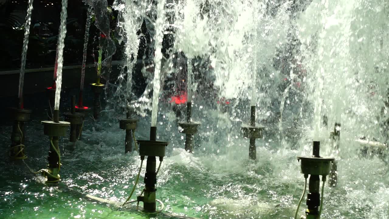 Getti d'acqua della fontana nel centro commerciale. Movimento rallentato