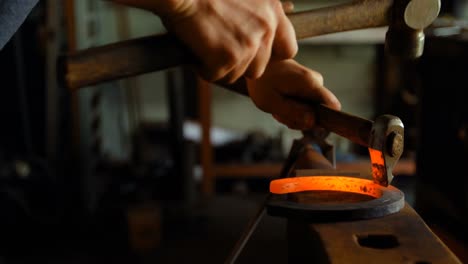 female metalsmith molding horseshoe in factory 4k