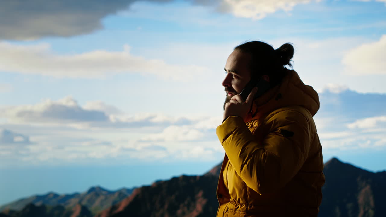 el excursionista disfruta del paisaje de gran altitud y hace una llamada telefónica