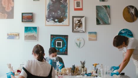 women in an art studio working on resin art projects