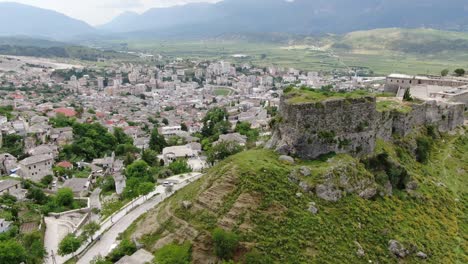 vista de avión no tripulado en albania volando en la ciudad de gjirokaster sobre un castillo medieval en una fortaleza de tierra alta que muestra las casas de techo marrón de ladrillo