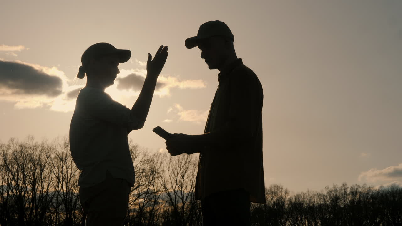Silhouette di due persone che discutono al tramonto
