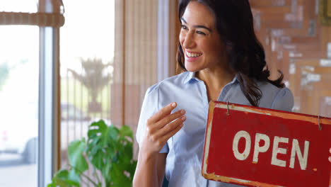 Lächelnde-Frau-Mit-Einem-Offenen-Schild