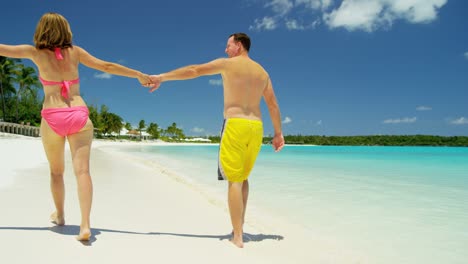 loving young caucasian couple in swimwear on beach